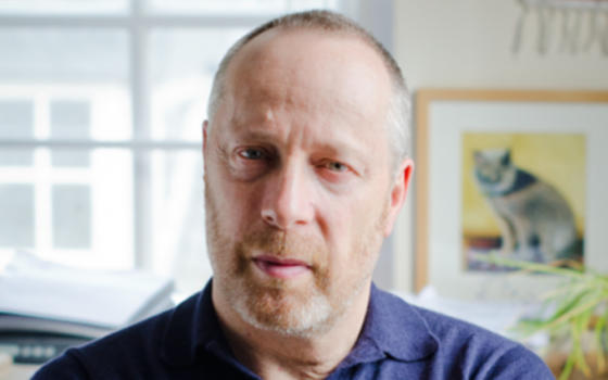 Close up of Professor Stephen Reicher FRSE wearing blue collared top. Stephen has a beard and close cropped hair.