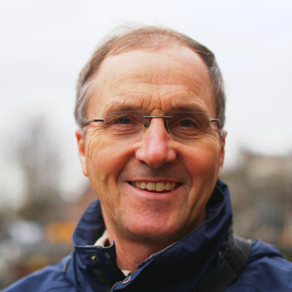 Image of Professor Ian Bod. He has short hair, wears glasses and is smiling. He is wearing a blue jacket.