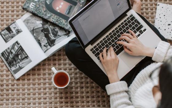 Image of hands, laptop and cup of coffee