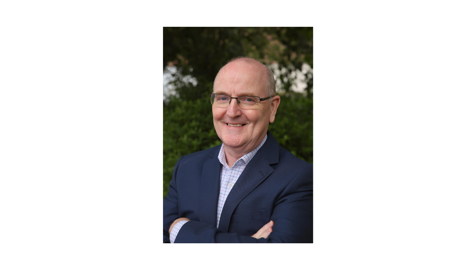 Eddie McConnell smiles at the camera with his arms crossed.