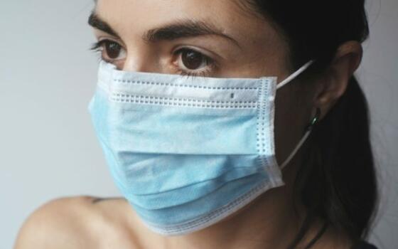 A woman wearing a blue face mask.