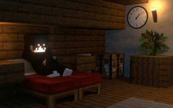Made as a blocky minecraft animation, a characters sits lit by a laptop screen on a bed.